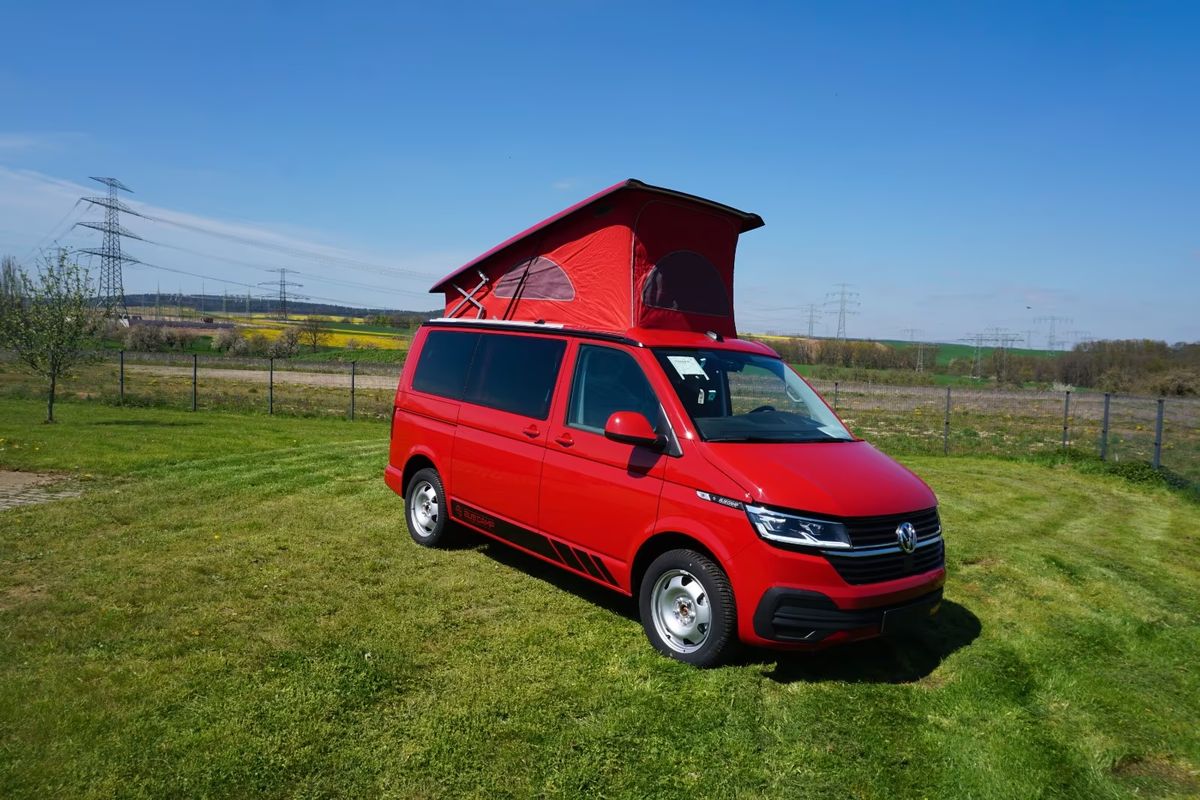 VW T6.1 in Kirschrot, Ansicht schräg von vorn mit geöffnetem Aufstelldach